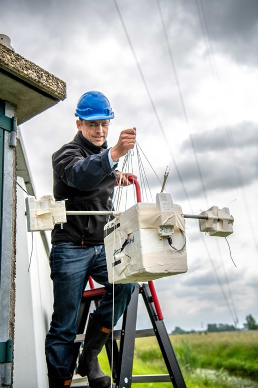 A sonde team member holding a multi-rigged sonde payload with a radiosonde, dual NO2 sondes and an ozone sonde, after calibration, just before launch. Picture credit: Arnoud Apituley
